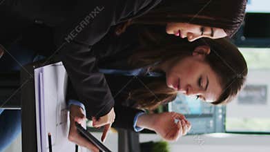 Vertical Video Real estate agency employees designing building blueprints