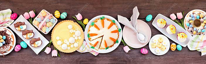 Easter or spring dessert food table scene. Above view over a dark wood banner background.