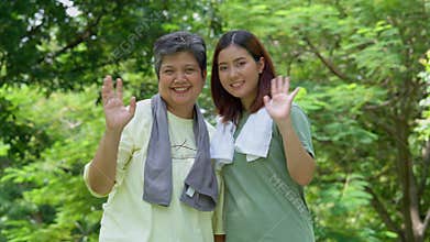 Attractive Senior mother and daughter working out together in the morning exercise in the park. Daughter absorbs sweat from her