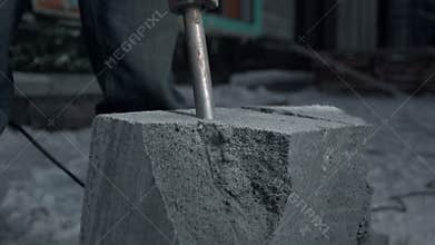 Close up of drilling a cement block. Clip. Industrial works at the construction site.