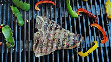 T- bone steak grill with vegetables on a cast iron barbecue. Top view