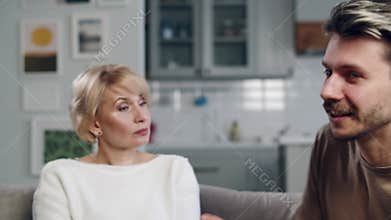 Clarification of relations. Old mom arguing with her adult son. Stressful situation. Mid shot two generations conflict