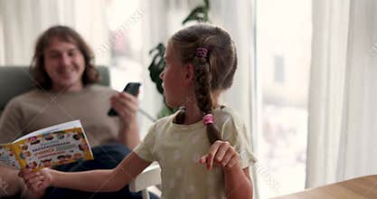 Girl shows father picture drawn with bright felt-tip pens