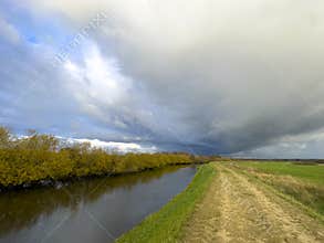 Dramatic cloudscape over Wieprza river dike in Poland