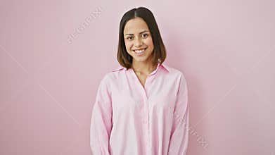 Lucky young hispanic woman flaunting a cool, confident smile on her beautiful face while standing solo against a pink isolated