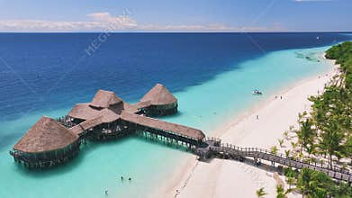 Aerial view of bungalow, white sandy beach, sea and palms
