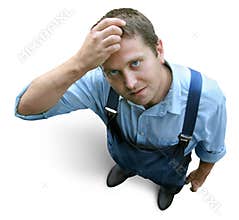 Young worker in working clothes, wondering and hesitating. Looked from above.