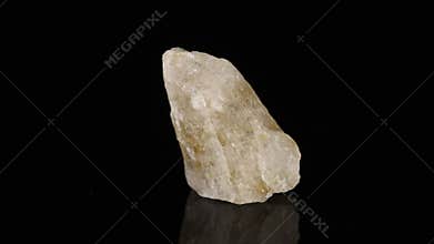 Polished mineral stone Rutile in quartz in zoisite rotates in a circle on a black background