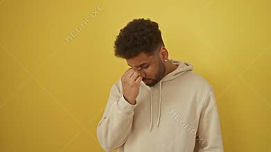 Stressed-out african american man in hoodie, rubbing tired eyes and aching head - portrait of fatigue and frustration against