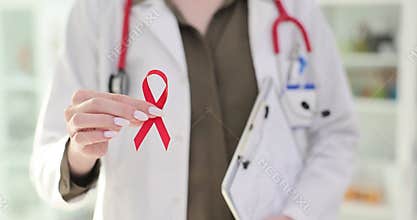 Doctor or nurse holds red ribbon and symbol for World AIDS Day