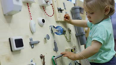 Little child explores home related objects on