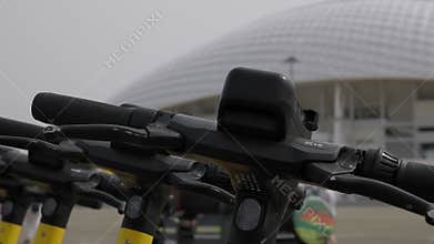 Close-up of a row of electric scooters in the park in summer for rent.