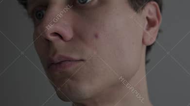 Man noticing single pimple on his face, examining skin in mirror, acne and blemish problem, realistic skincare and self care