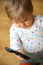 Baby with a TV remote control