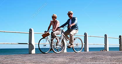 Active seniors going on a bike ride by the sea