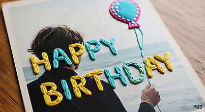Person holding balloon with happy birthday letters on board in indoor setting