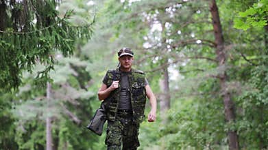 Young soldier or hunter with gun in forest