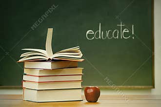 School books and apple on desk