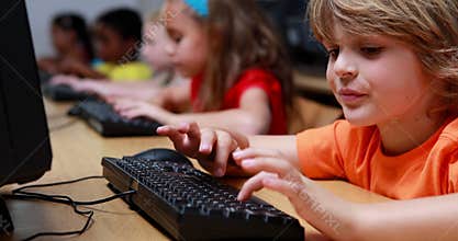 Little boy smiling at camera during computer class