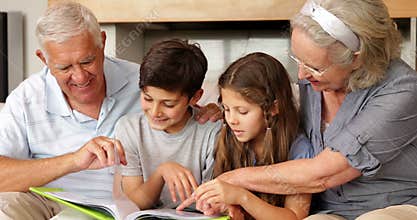 Grandparents chatting with grandchildren looking at photo album