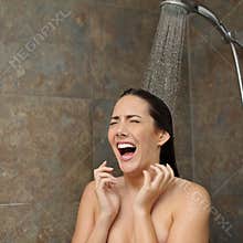 Disgusted woman screaming in the shower under cold water