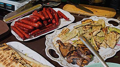 Picnic on the table, tomatoes, grilled peppers, mushrooms on plates, grilled salads, marinated red onions, fried