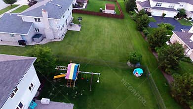 Aerial view houses in residential suburban neighborhood with backyard landscape and rooftops