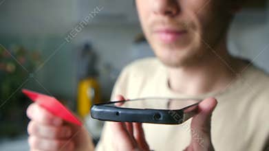 Man dictating credit card information to phone scammer
