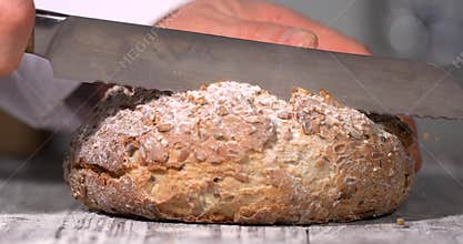 Super slow motion, Rustic Bread Cut With Flourish. Warm Studio Scene With Chef Cutting Crusty Sourdough