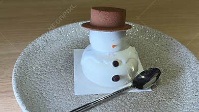 Chocolate snowman dessert melting mousse cake on silver plate cutting with spoon fork sweet festive pastry gourmet