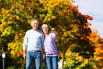 Seniors in autumn or fall walking hand in hand
