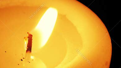 Close-up of a candle flame against a black background.