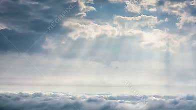 Time-lapse scene of cloudy sky with ray of sun light over city
