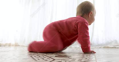 Cute baby crawling on tiled floor