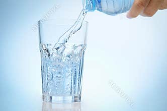 Pure water is emptied into a glass of water from bottle