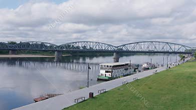 Scenic view of the Vistula riverfront in Torun with modern road bridge and floating restaurants