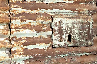 Peeling paint and rusted metal with keyhole