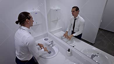Young Businessman Washing Hands in a Modern and Clean Public Restroom During a Work Break