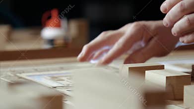Hands of Professional Man Constructing Architecture Model of Urban City Building