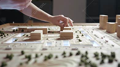 Hands of Professional Man Constructing Architecture Model of Urban City Building