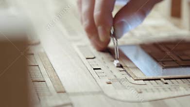 Hands of Professional Man Constructing Architecture Model of Urban City Building