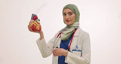 Muslim lady cardiologist holds anatomical model of human heart