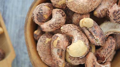 closeup of cashew nuts in a wooden bowl .