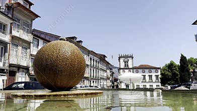 stone fountain with a round water sphere stands on a
