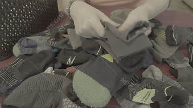 Woman folding and matching clean laundry socks