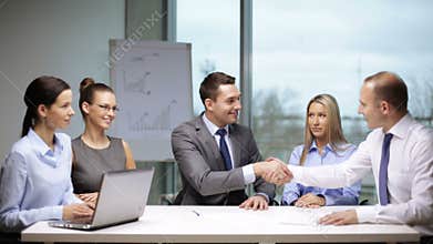 Businessmen signing a contract and shaking their