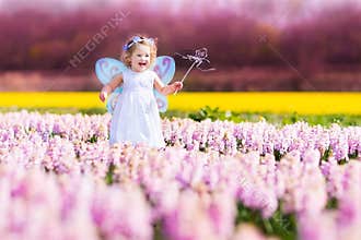 Cute toddler girl in fairy costume in a flower fie