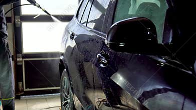 Close-up of interior cleaning in a car. A worker dirty car water blaster with a vacuum cleaner. Car dry cleaning.