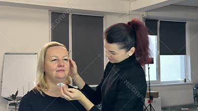 Beauty salon skin care master applies to woman micellar water tonic to moisturize and cleanse the skin youth anti-aging