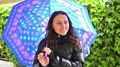 Teen with umbrella in a garden